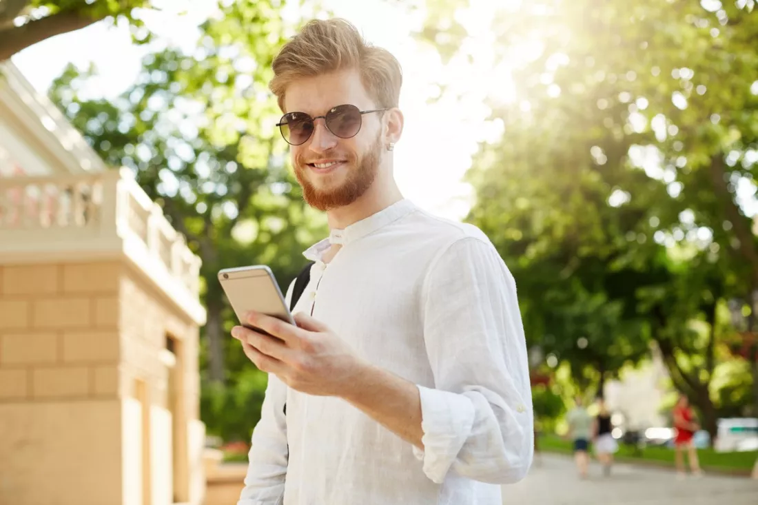 Junger Mann prüft sein berufliches Profil auf dem Handy